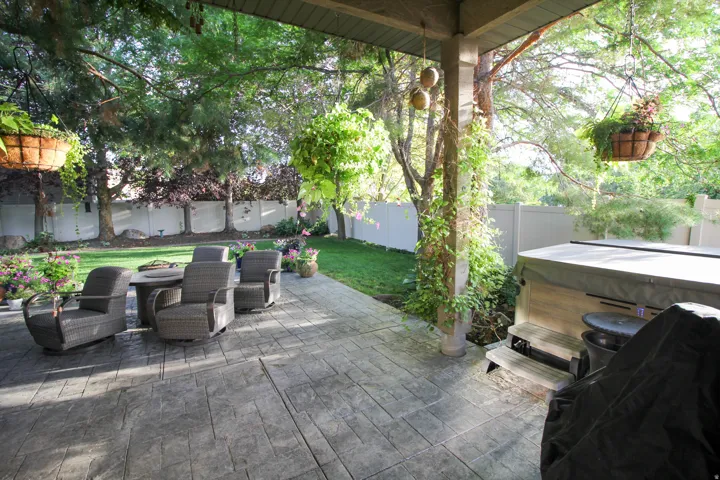 Fenced backyard with a hot tub and a patio area