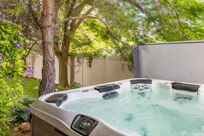 Outdoor spa with a gray composite exterior, integrated control panel, and multiple seating areas
