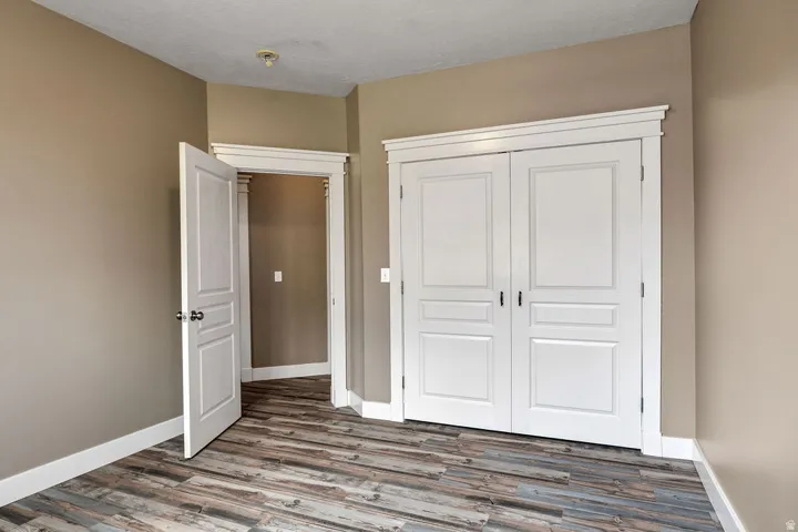 Room featuring wood-finish flooring, neutral wall paint, and white trim