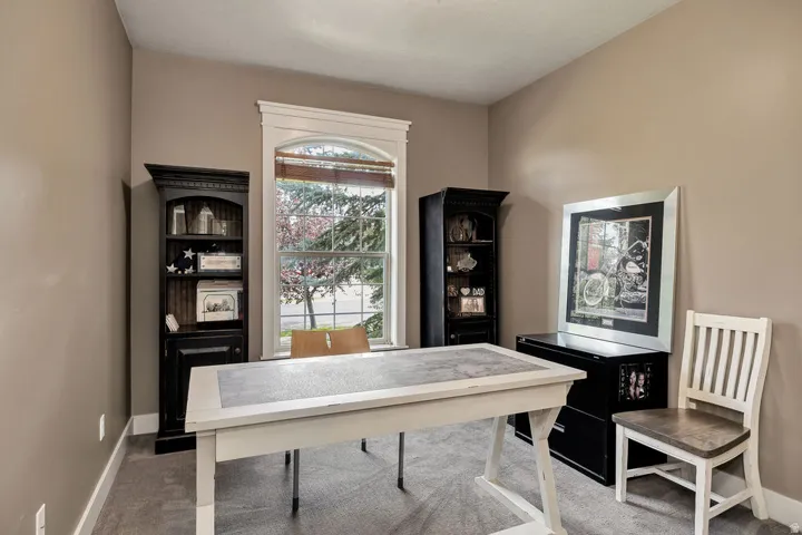 Room with a single arched window featuring white trim and wood-finish blinds