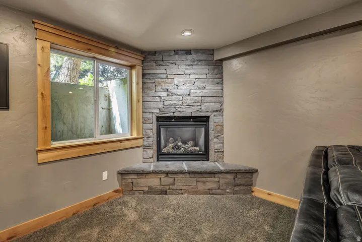 Corner fireplace featuring a stacked stone surround and hearth