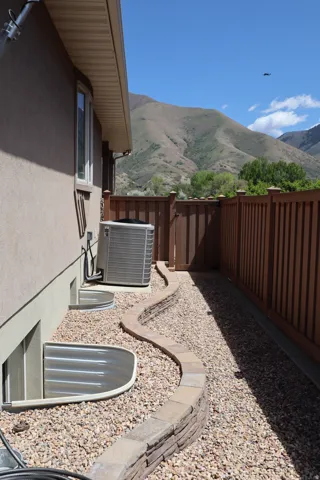 Stucco exterior with a stone-accented curved retaining wall and gravel landscaping