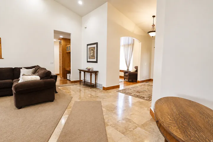Vaulted ceilings enhance the bright interior featuring recessed lighting and an arched entryway