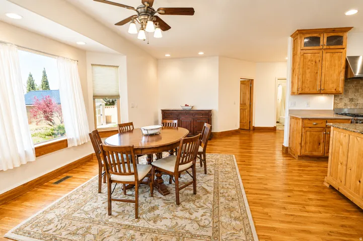 Open-concept dining area featuring wood-finish flooring, recessed lighting, and a multi-pane bay window