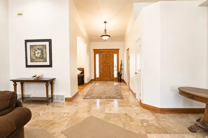 Foyer featuring natural wood double entry doors, neutral tile flooring, and high ceilings with recessed lighting