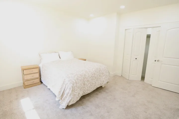 Bedroom featuring light-toned carpeting, neutral wall paint, and recessed lighting