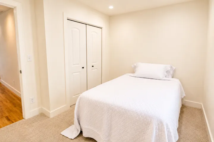 Carpeted room with a bi-fold closet and recessed lighting
