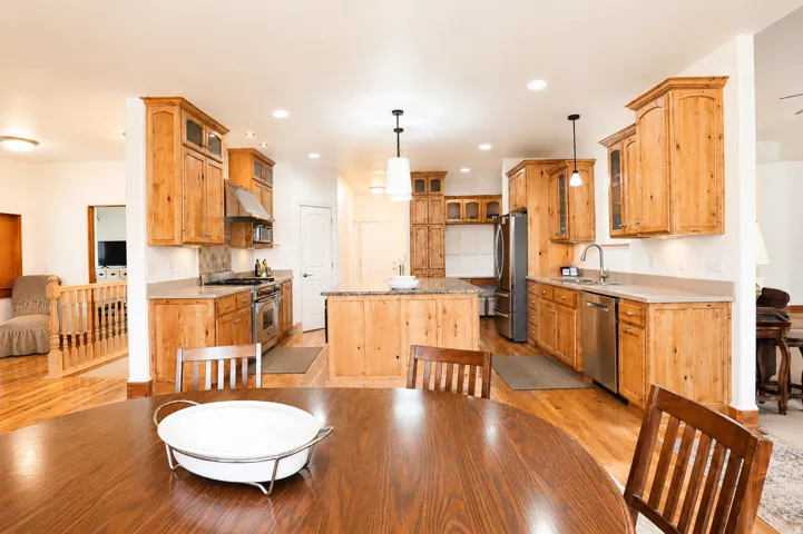 Bright kitchen featuring wood-finish cabinetry, stainless steel appliances, a central island with countertop, and recessed lighting