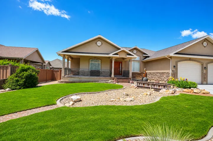 Stucco exterior with stone accents and a covered front porch featuring wrought iron railing