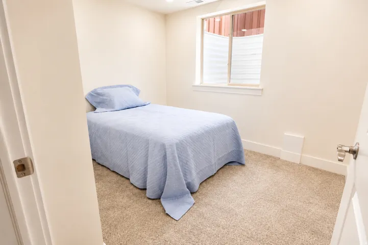 Carpeted room featuring light-colored walls, a single window with blinds, and white trim