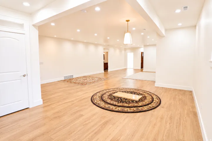 Expansive open-concept living space featuring wood-finish flooring and recessed lighting throughout