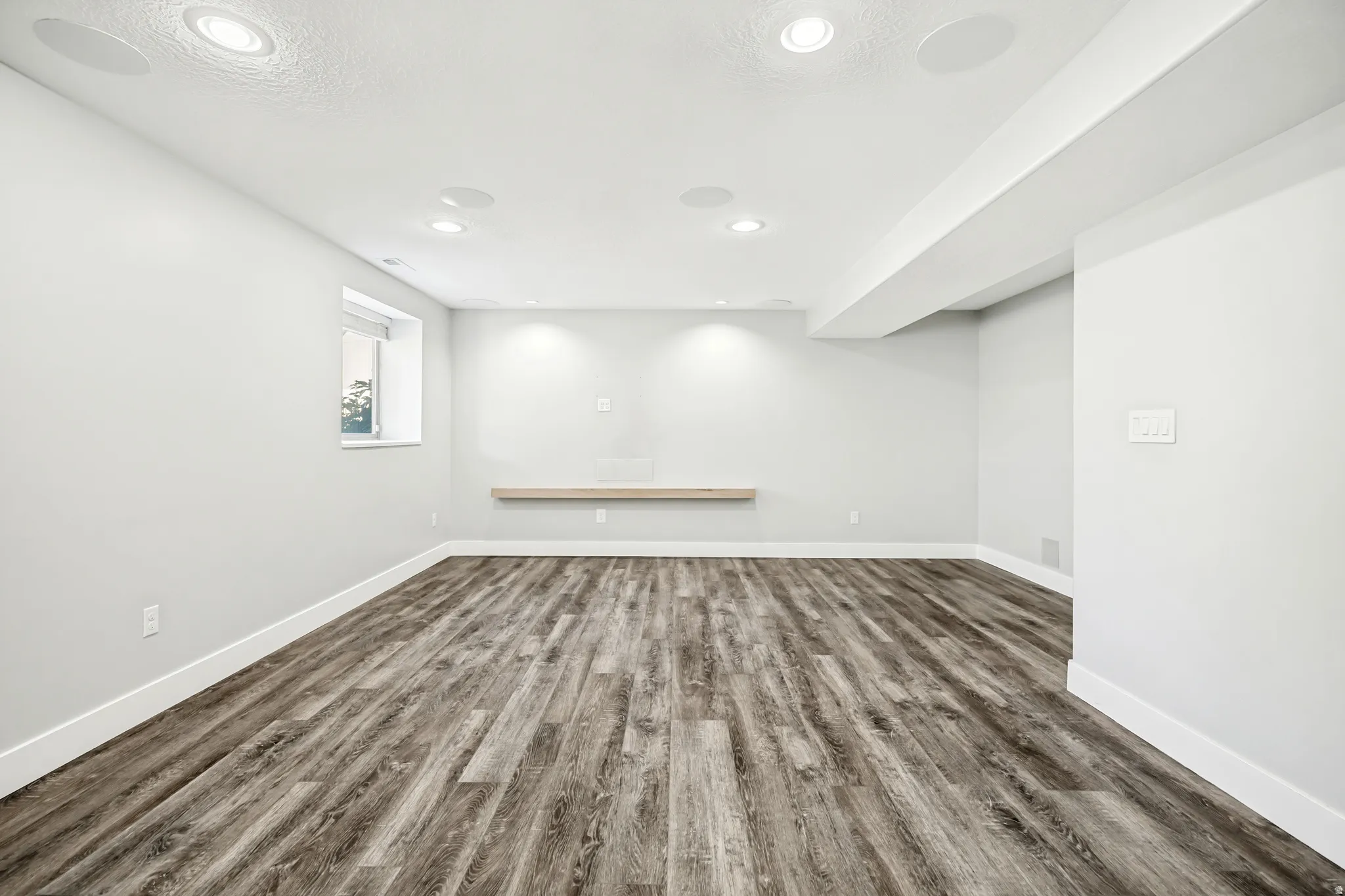 Basement with dark wood finished floors and recessed lighting