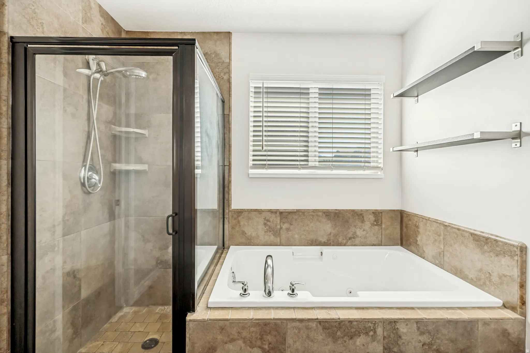 Full bath with a shower stall and a jetted tub