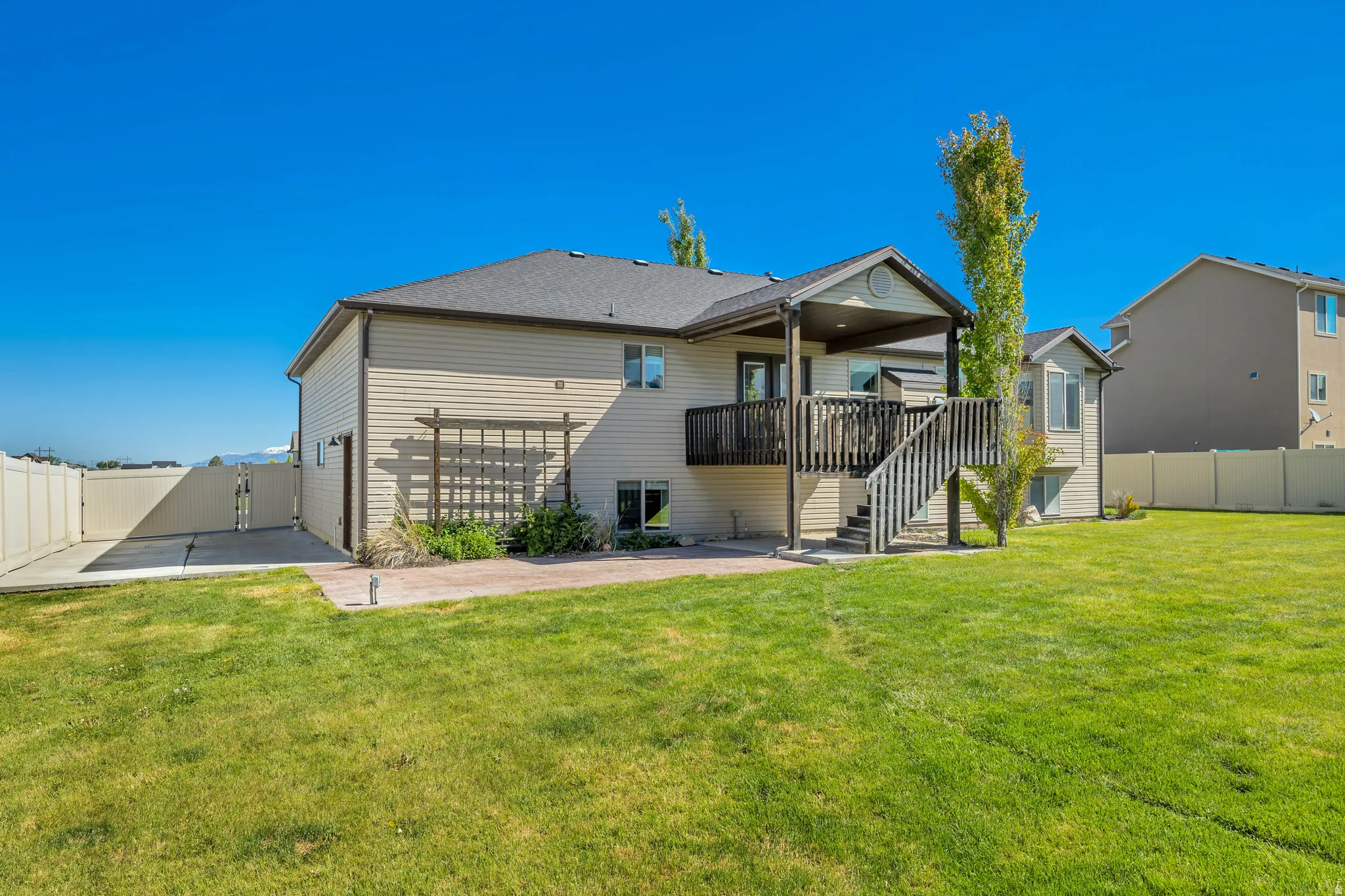 Rear view of house with a fenced backyard and a gate