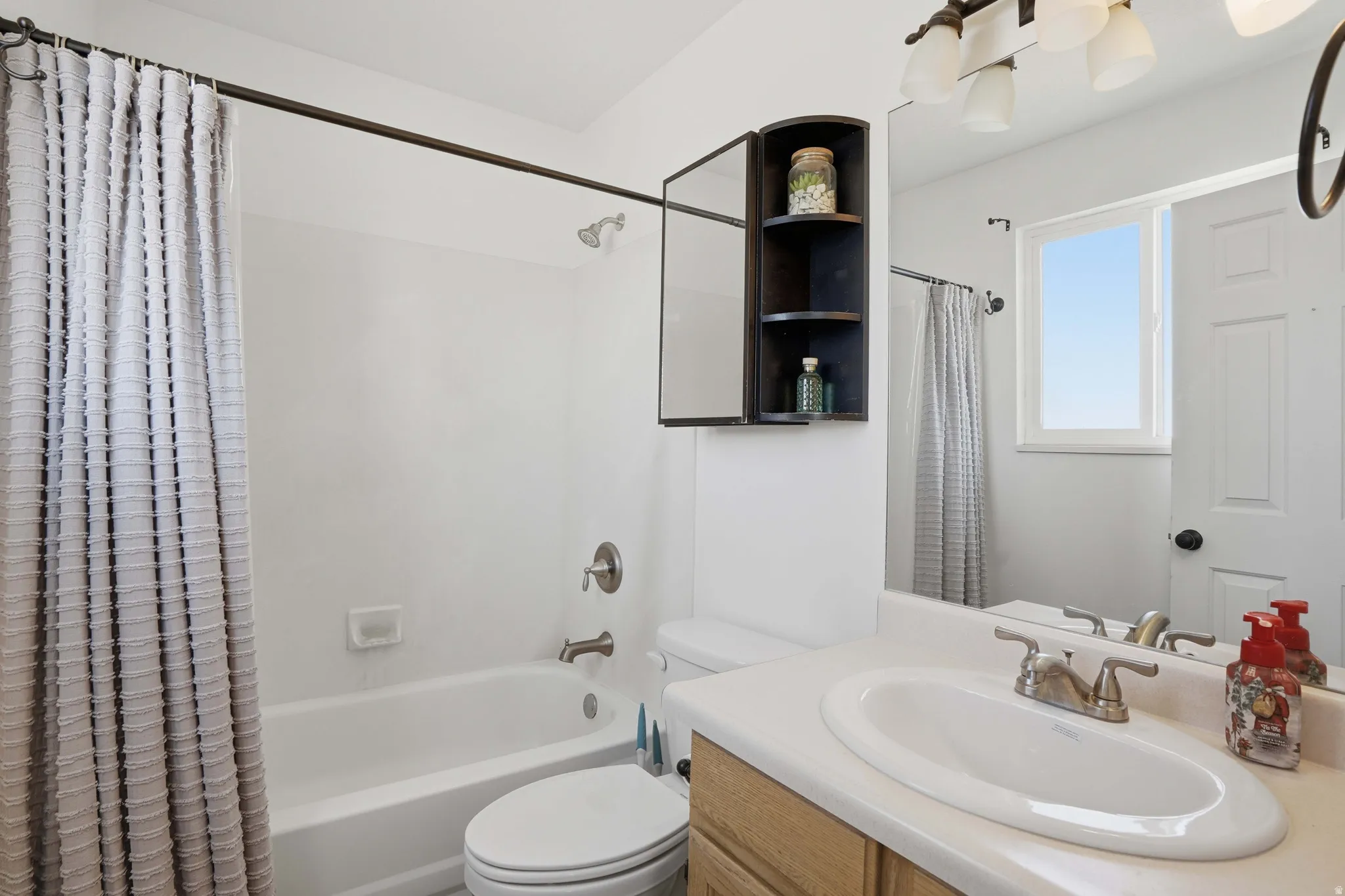 Bathroom with vanity and shower / bathtub combination with curtain