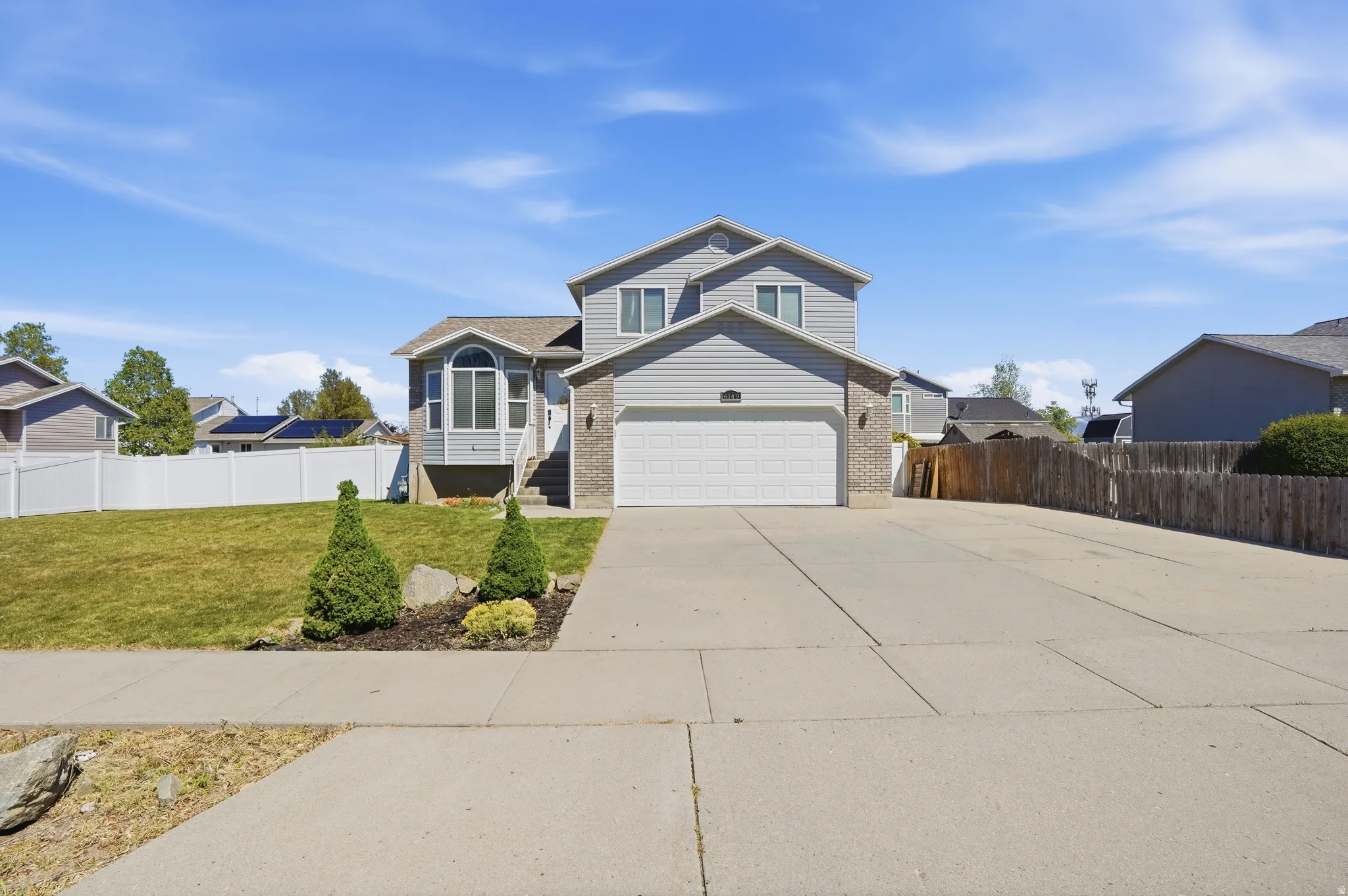 View of front facade featuring brick siding, concrete driveway, and a garage