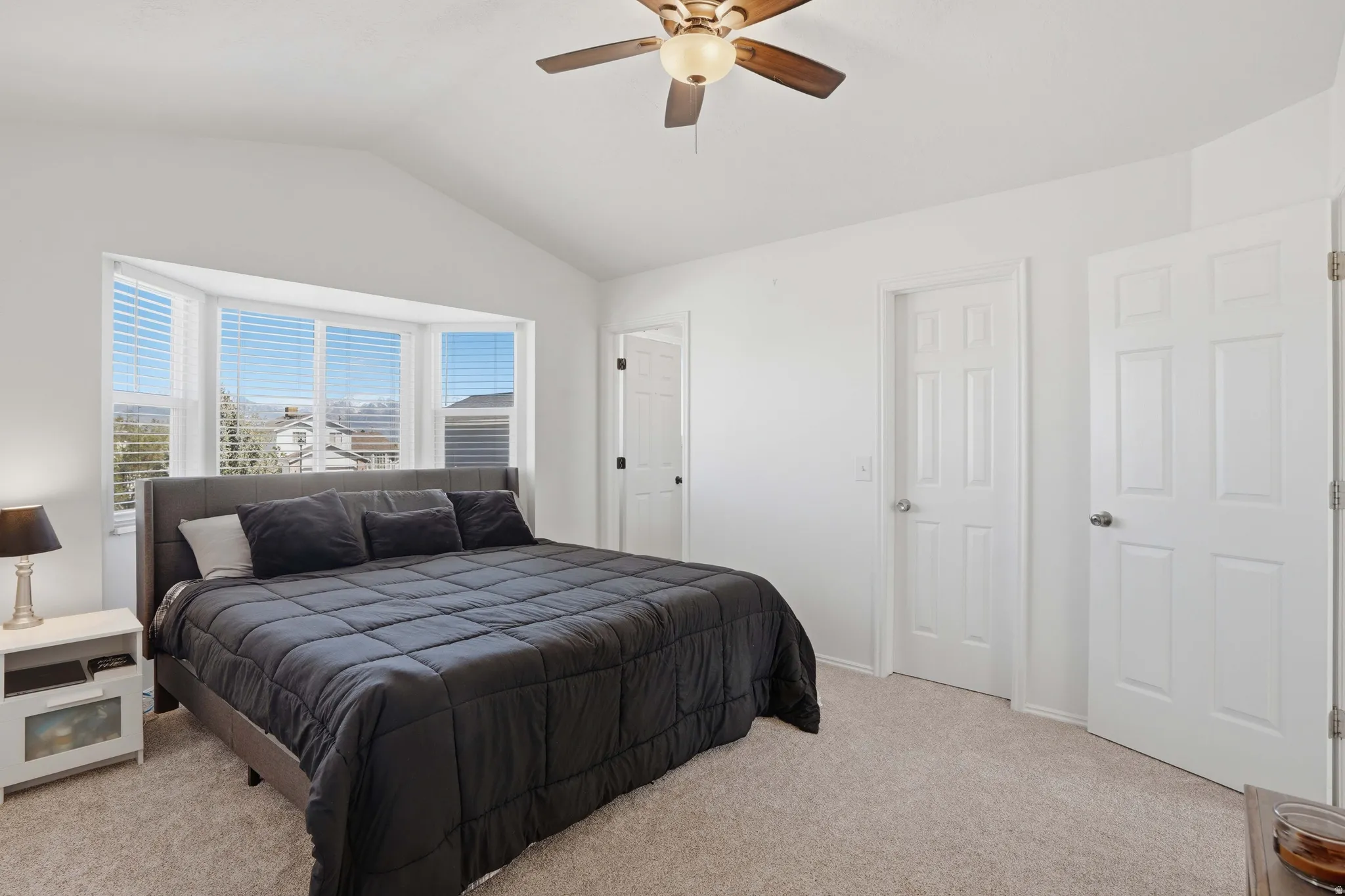 Bedroom with light colored carpet and a ceiling fan