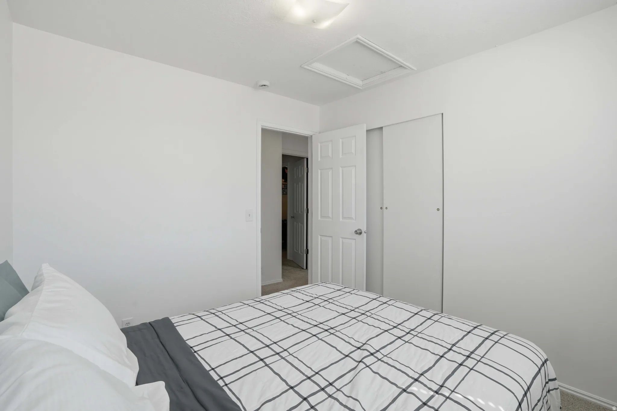 Carpeted bedroom featuring attic access and a closet