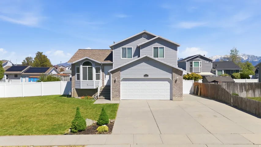 View of front of house featuring concrete driveway, a residential view, a garage, and brick siding