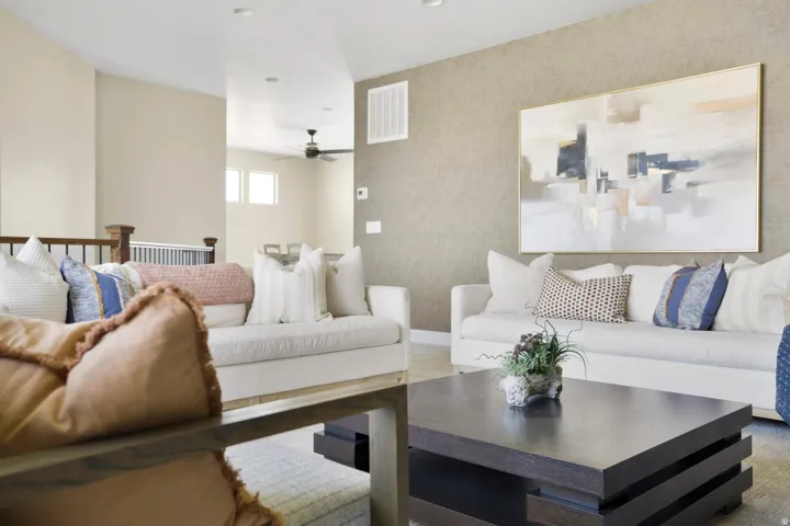 Carpeted living room with wallpapered walls and a ceiling fan