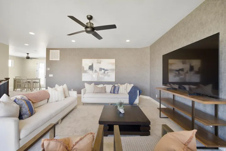 Living room with light carpet, ceiling fan, and recessed lighting