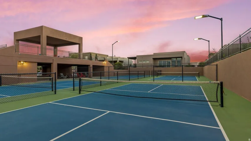 View of tennis court featuring a balcony