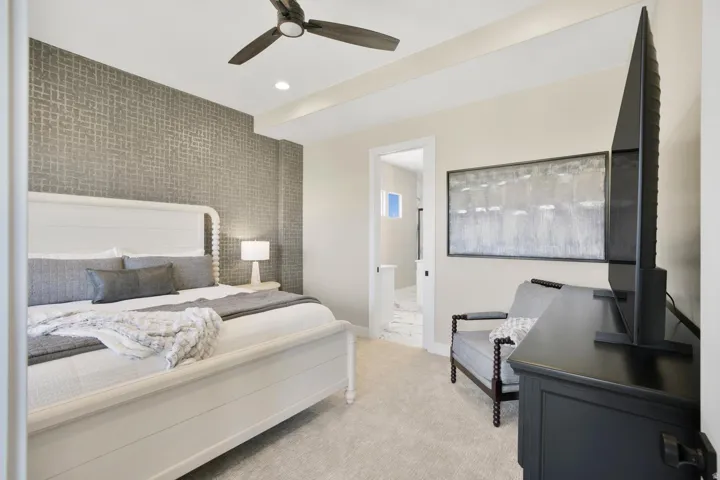 Bedroom featuring an accent wall, ceiling fan, recessed lighting, light colored carpet, and connected bathroom