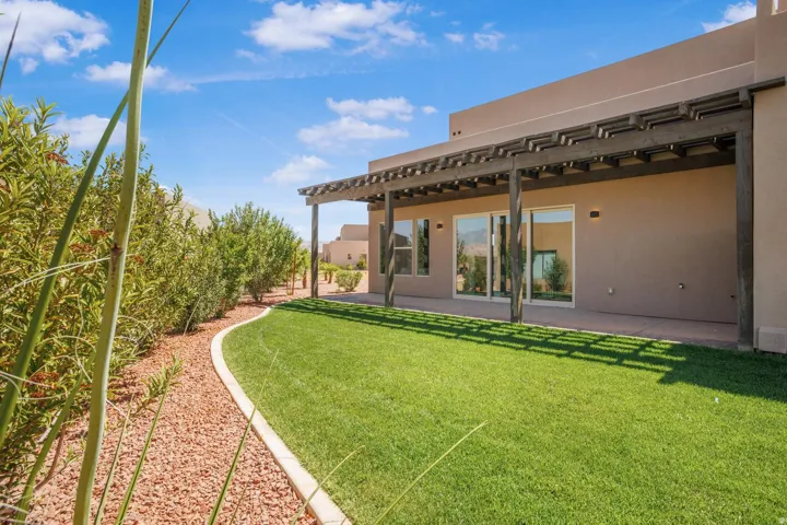View of grassy yard with a pergola and a patio area