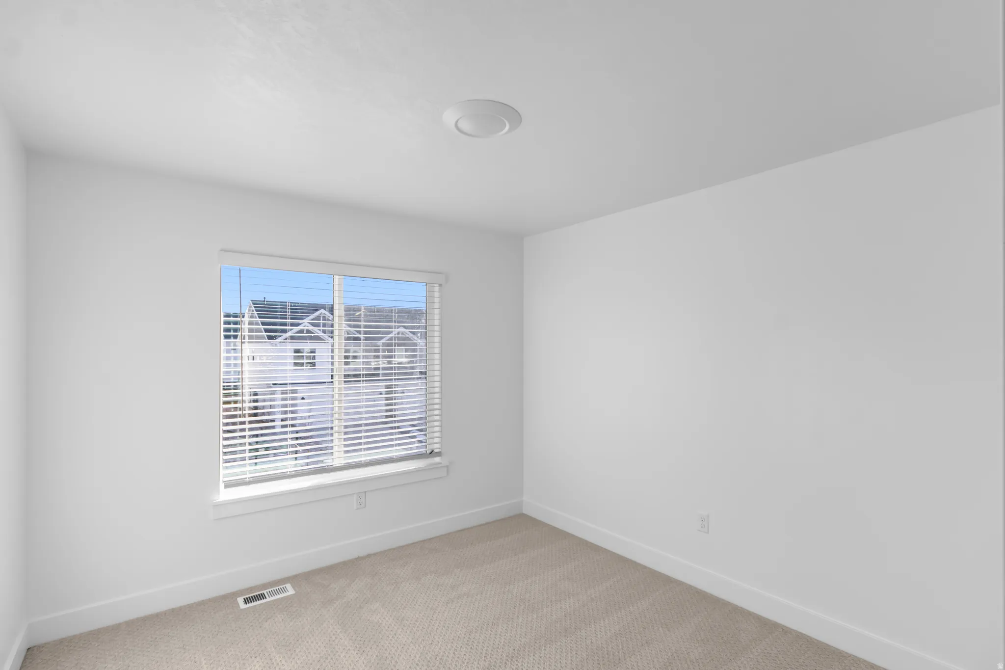 Unfurnished room with light colored carpet and baseboards