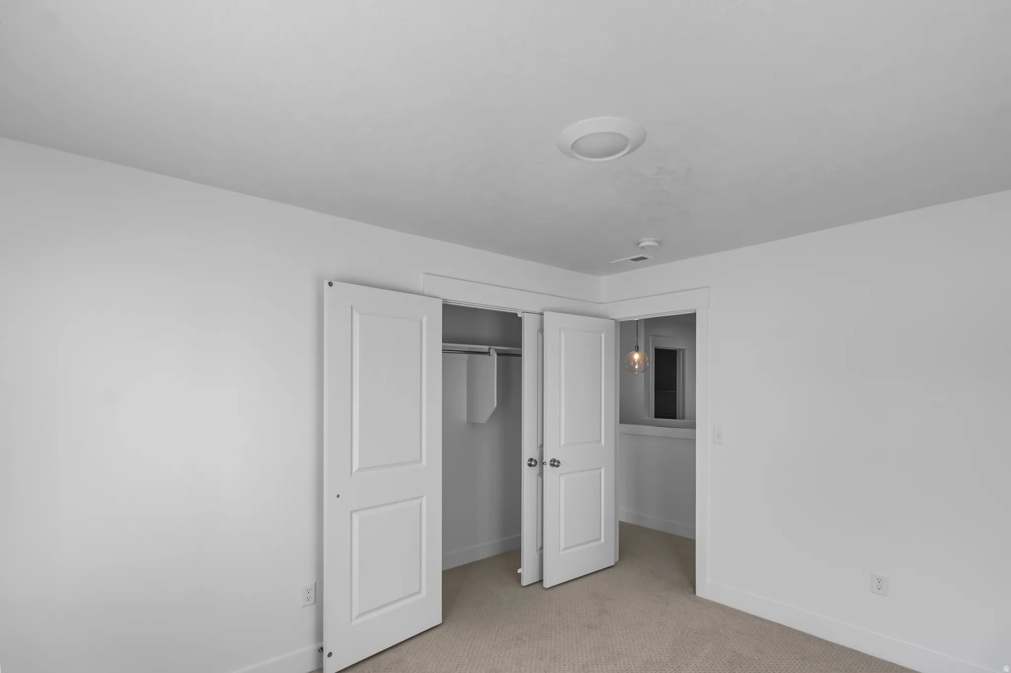 Unfurnished bedroom with light colored carpet and a closet