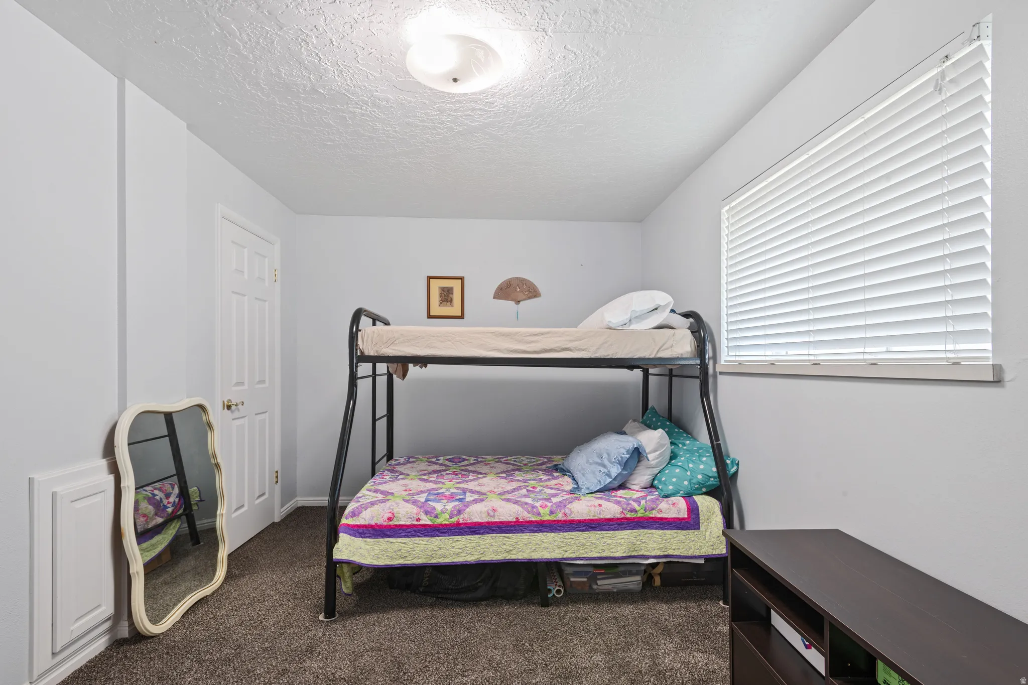 Bedroom featuring dark colored carpet and a textured ceiling