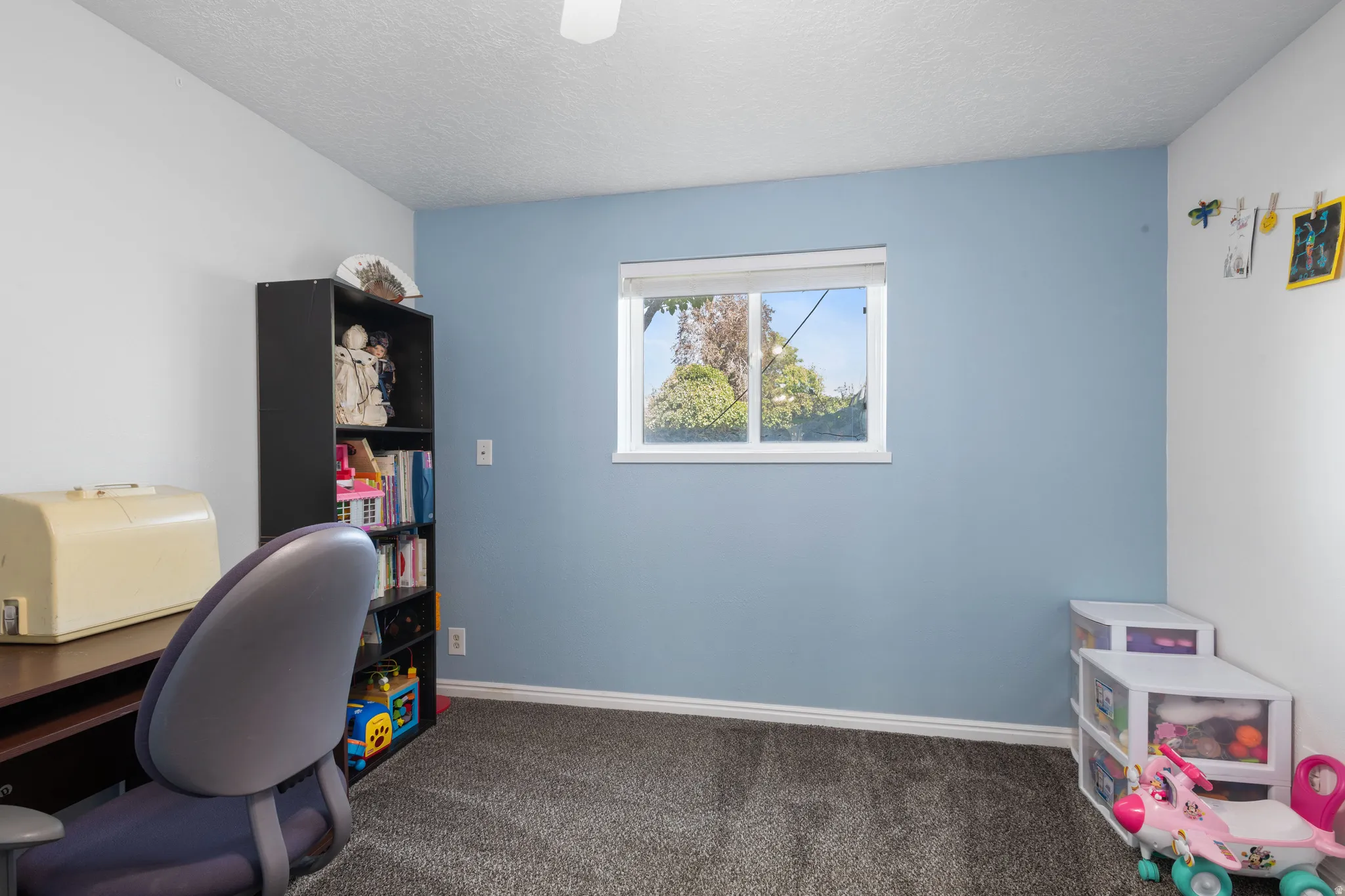 Office featuring a textured ceiling and dark colored carpet