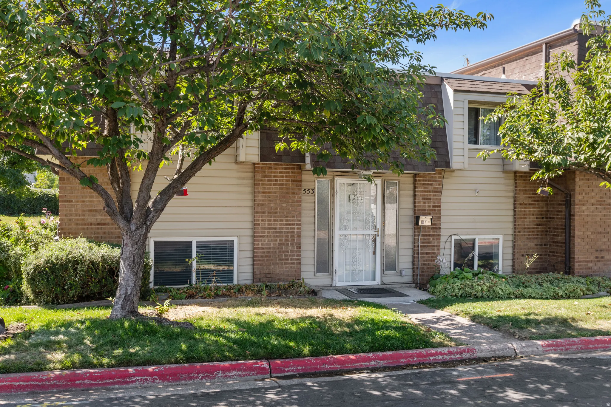 View of front of property featuring brick siding and a front yard