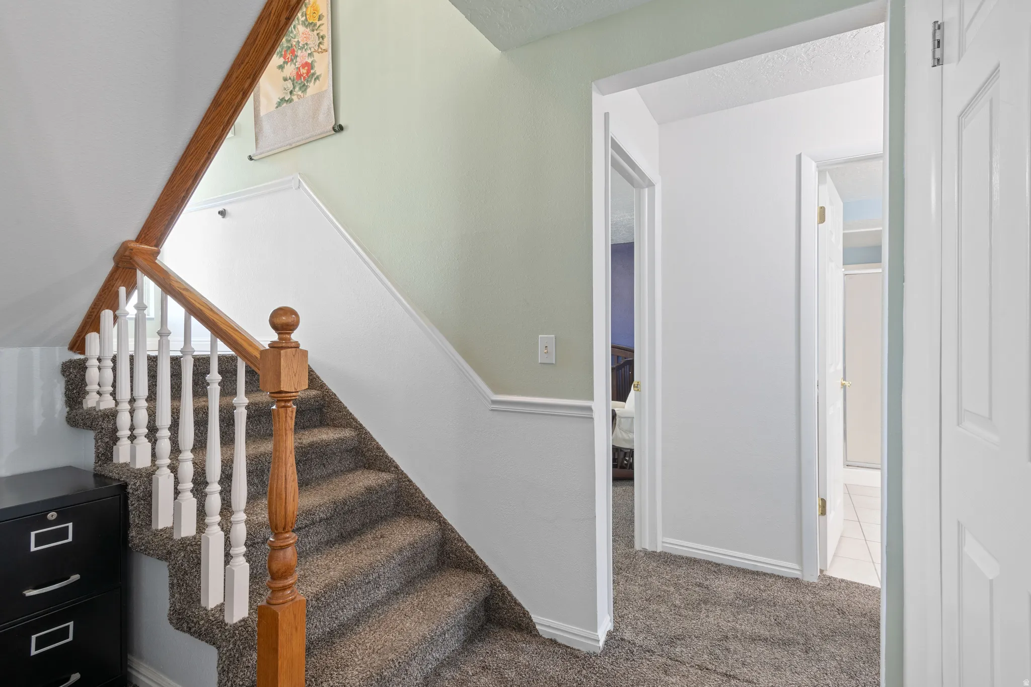 Stairs featuring carpet floors and a textured ceiling