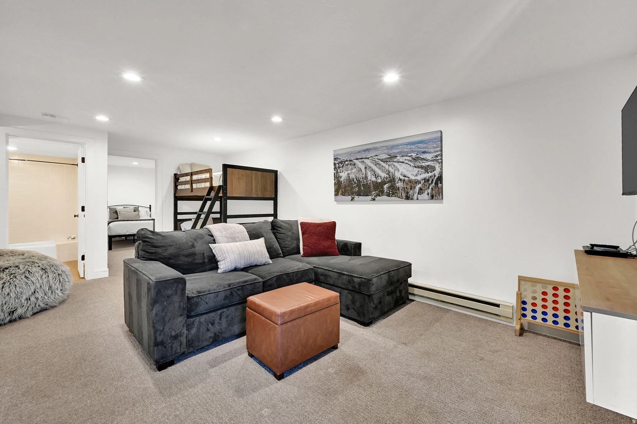 Downstairs living room with carpet, flexible occupancy space, full bathroom, nook for various functions.