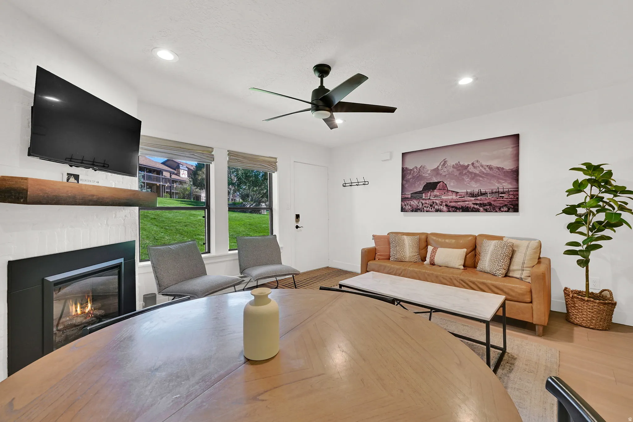 Living room with modern finishes, fireplace, dining area, LVP flooring through-out main level, roman shades.