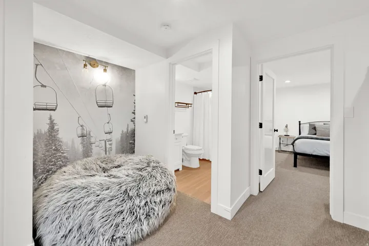 Downstairs living room with carpet, flexible occupancy space, full bathroom, nook for various functions.