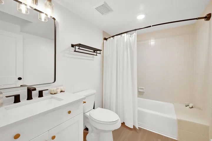 Downstairs full bathroom with tile surround and new vanity.