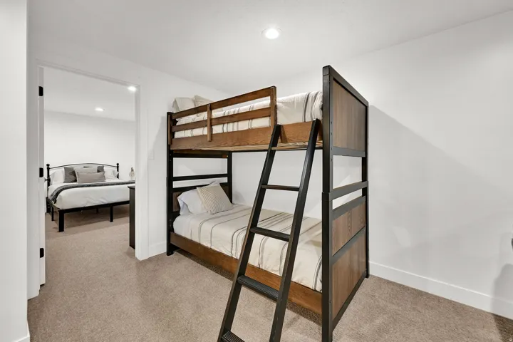 Downstairs living room with carpet, flexible occupancy space, full bathroom, nook for various functions.