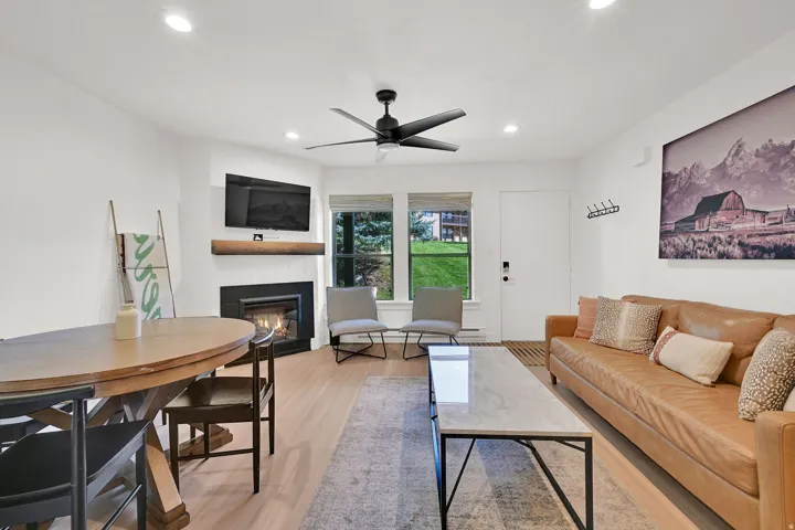 Living room with modern finishes, fireplace, dining area, LVP flooring through-out main level, roman shades.