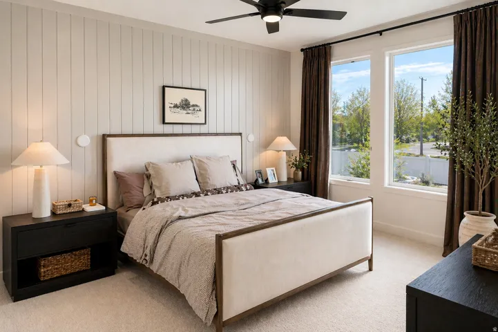 Carpeted bedroom with a ceiling fan and wood walls