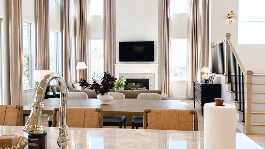 Living area with a high ceiling, a glass covered fireplace, and plenty of natural light