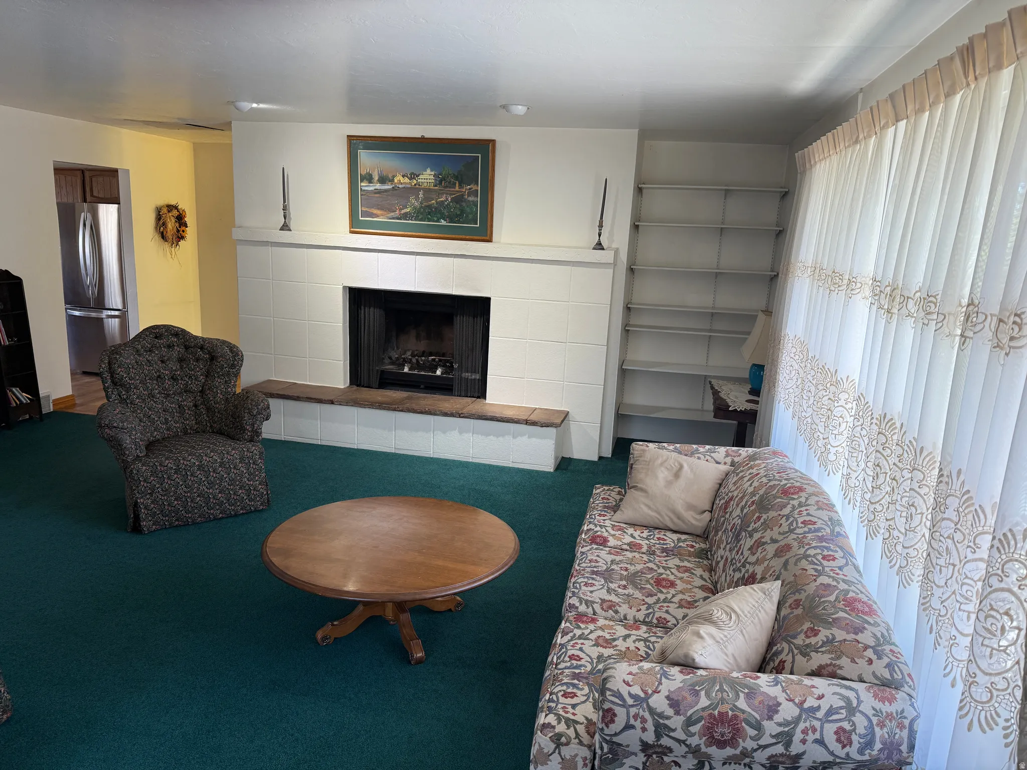 Carpeted living room with a tile fireplace