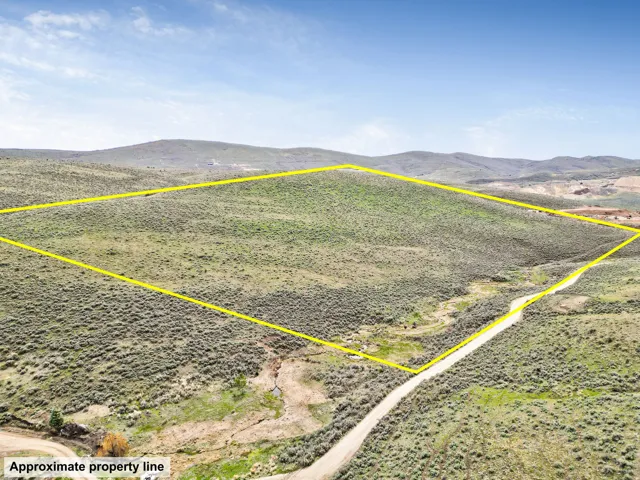 Overview of rural landscape with a mountainous background and property parcel outlined