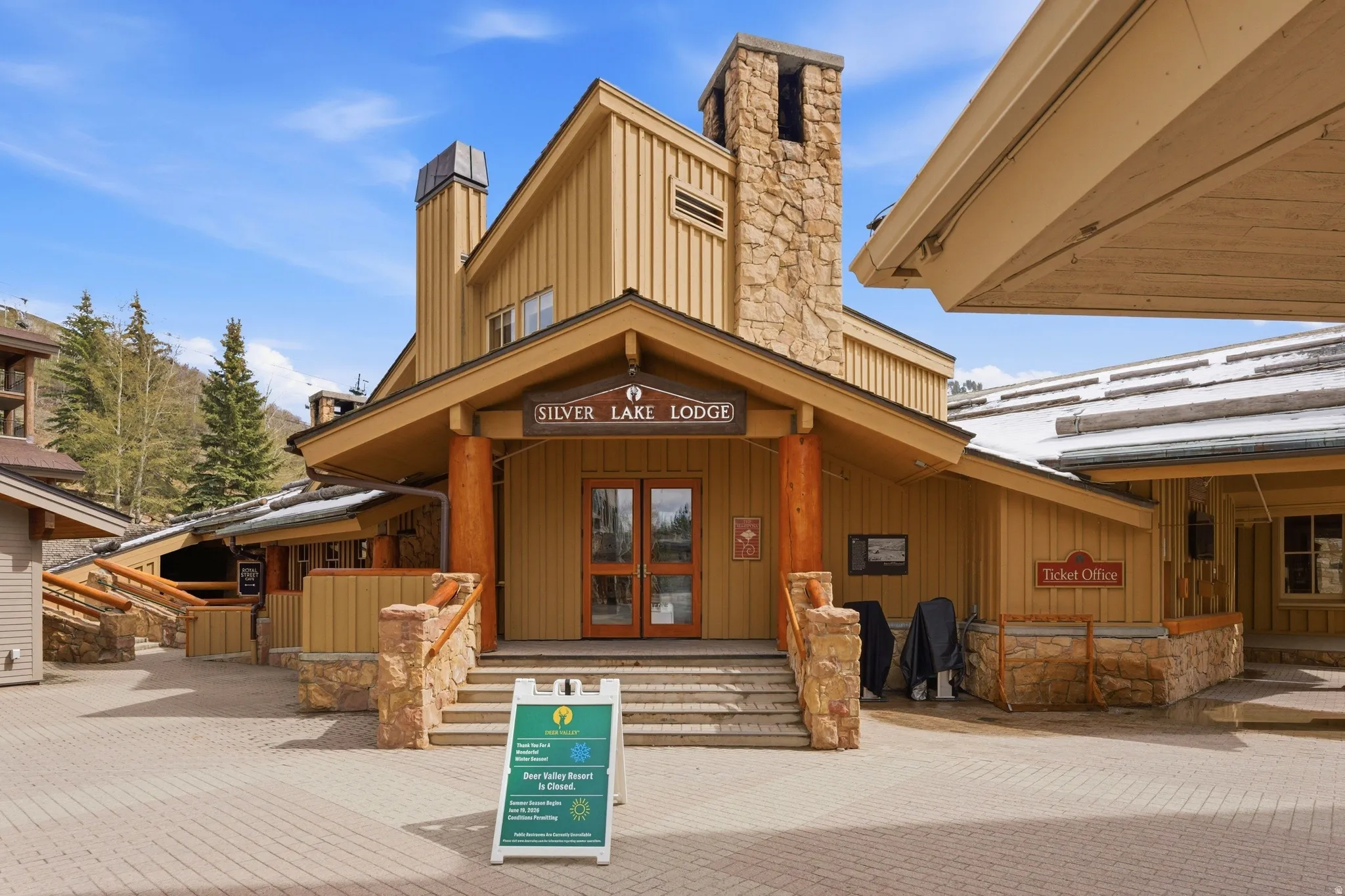 Lodge-style building featuring a prominent stone chimney and wood siding
