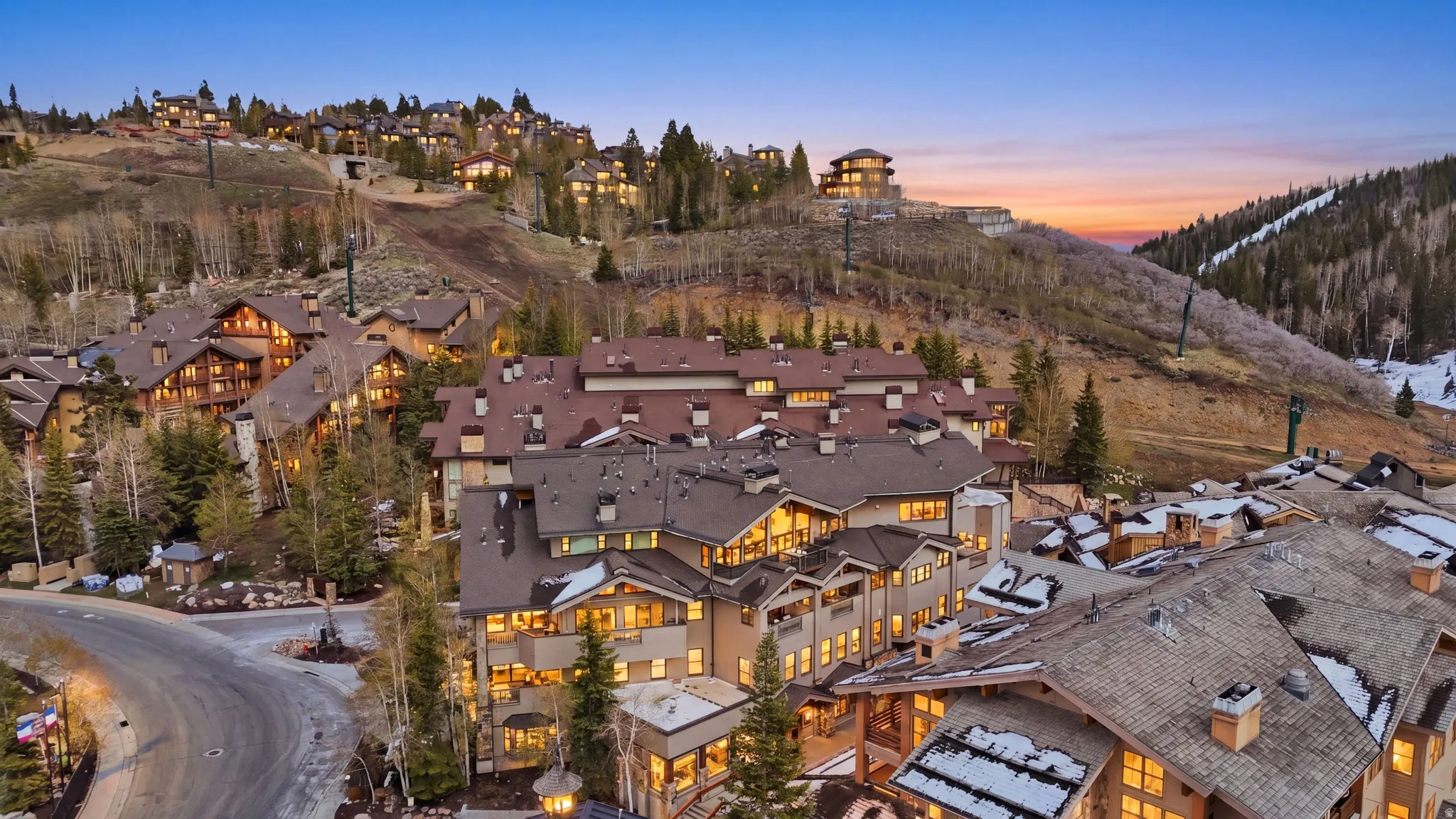 Expansive mountain resort with multi-story buildings featuring varied rooflines, numerous windows, and multiple balconies