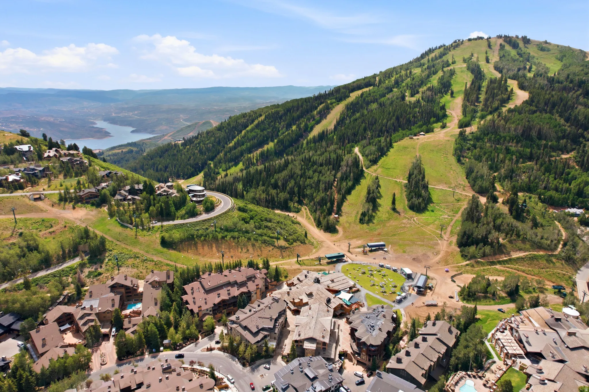 Aerial overview showcasing mountain-side residences nestled among extensive green forests