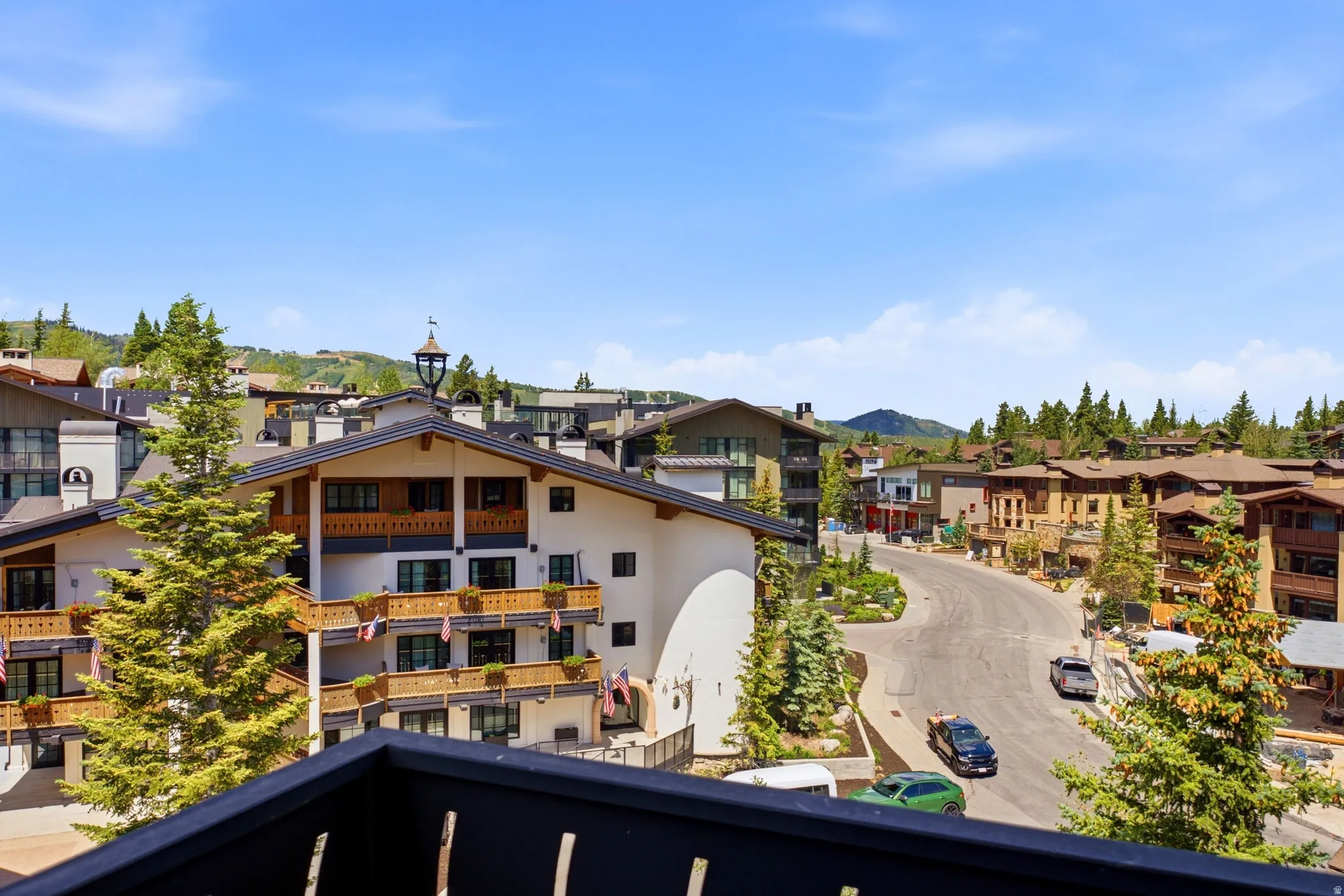 Black balcony railing framing a mountain village setting with diverse architectural styles