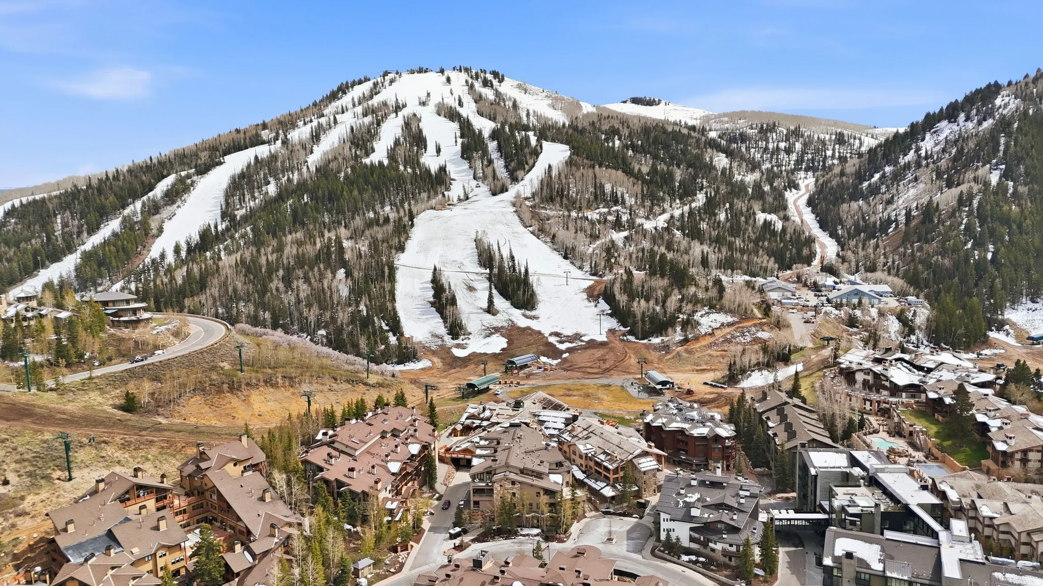 Mountainous terrain with snow-covered ski runs and densely forested slopes