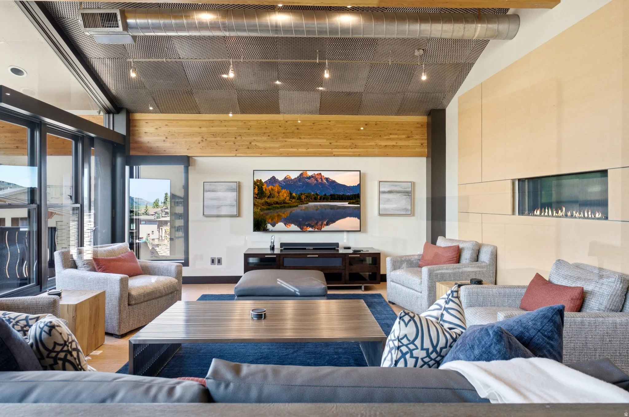 Open living space featuring wood-finish flooring and a distinctive ceiling with exposed ductwork